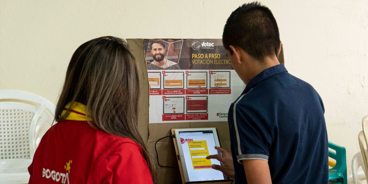 Imagen de personas votando por Urna Virtual de Votec