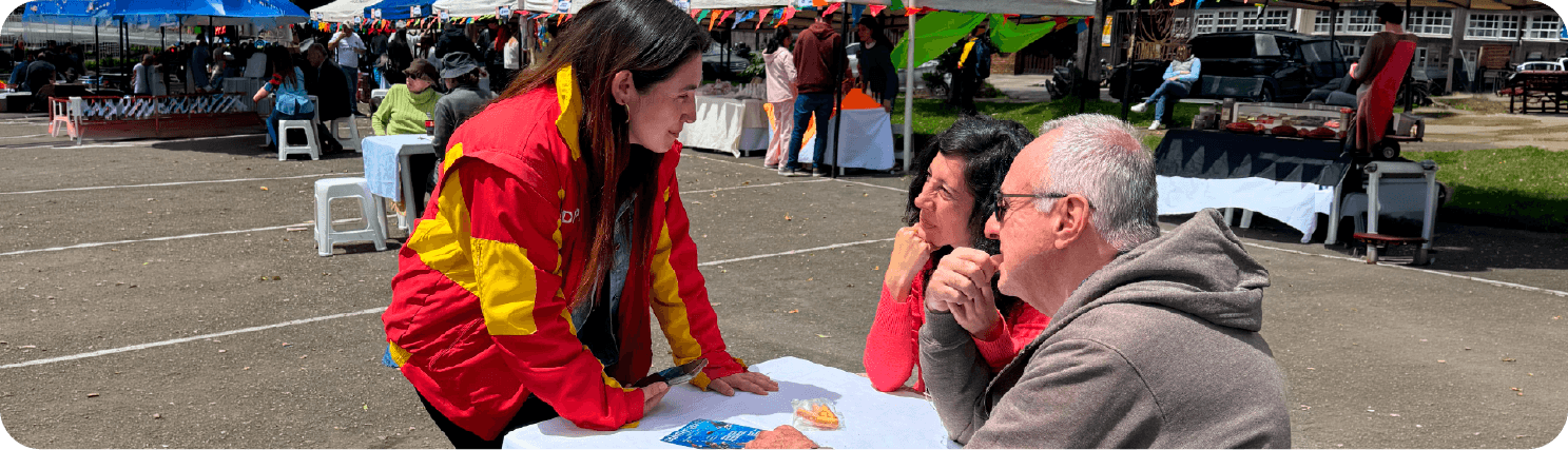 Ciudadanos interactúan con un funcionario durante un espacio de Retos Ciudadanos, aportando ideas y propuestas para la participación digital y la mejora de la gestión pública en Bogotá.