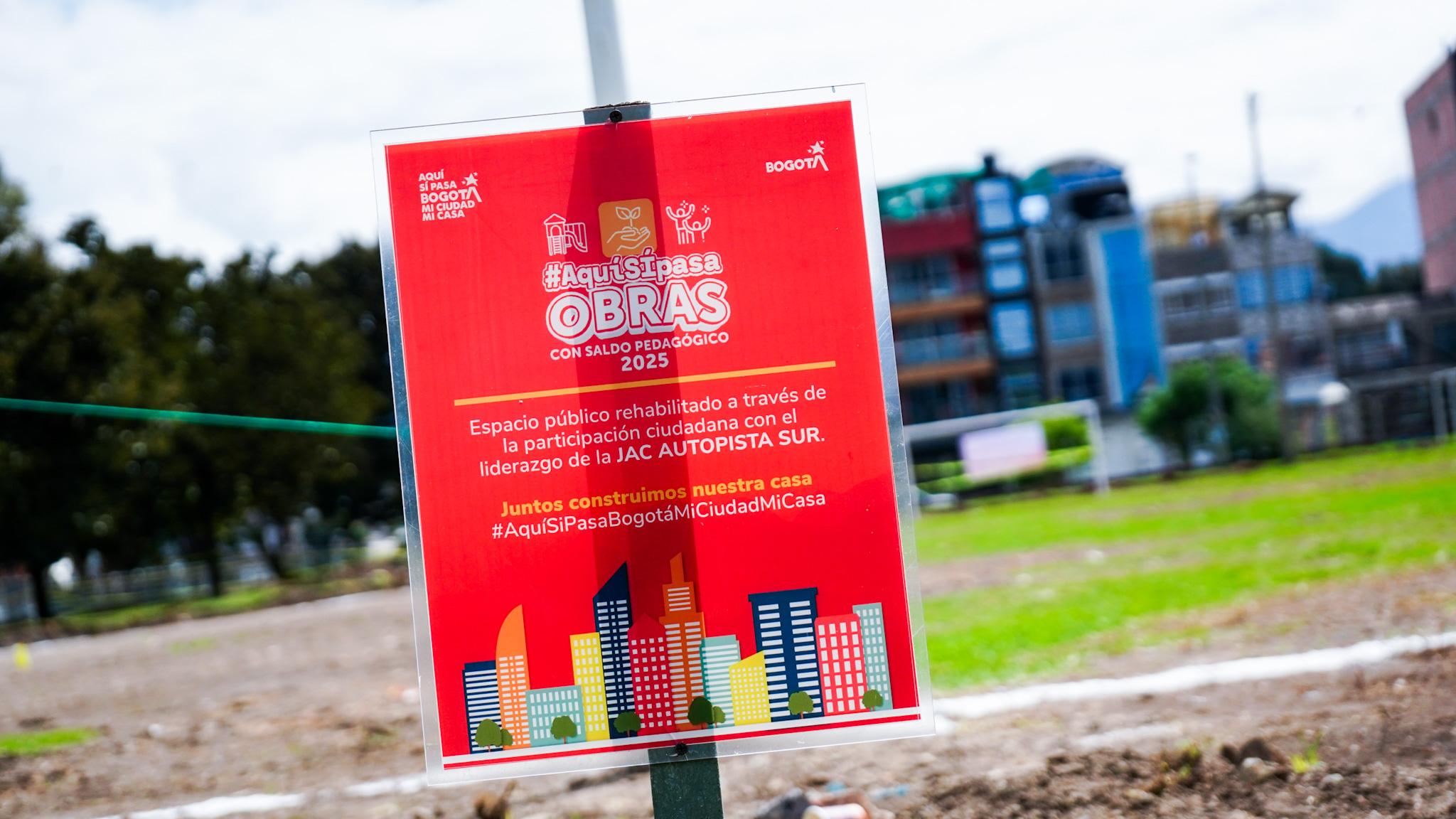 Aviso informativo del programa “Aquí Sí Pasa Obras con saldo pedagógico 2025” instalado en un espacio público rehabilitado de Bogotá.