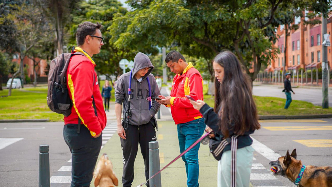 Grupo de vecinos de diversas edades conversan y comparten amigablemente en el salón comunal de un conjunto residencial en Bogotá, ejemplificando la convivencia ciudadana promovida por el IDPAC.