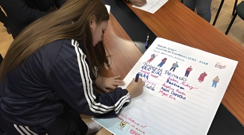 Joven firmando un Acuerdo de Confianza en actividad participativa del IDPAC en Bogotá
