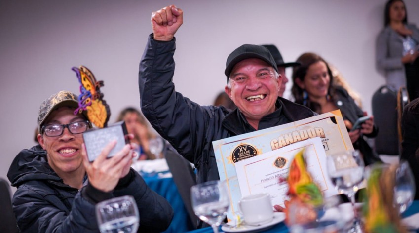 Ganadores celebrando en la XV Gala de Reconocimiento a la Participación, mostrando con orgullo sus trofeos y diplomas por su labor destacada en Bogotá