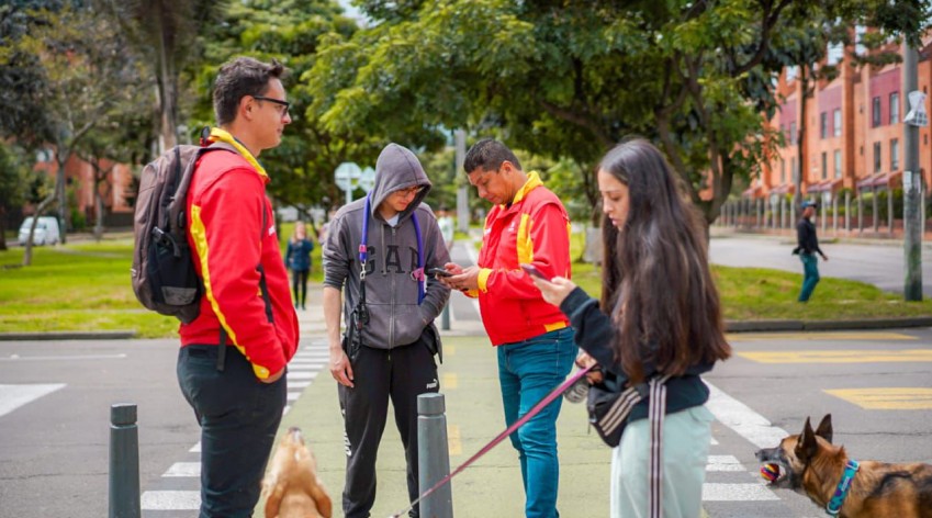 Grupo de vecinos de diversas edades conversan y comparten amigablemente en el salón comunal de un conjunto residencial en Bogotá, ejemplificando la convivencia ciudadana promovida por el IDPAC.