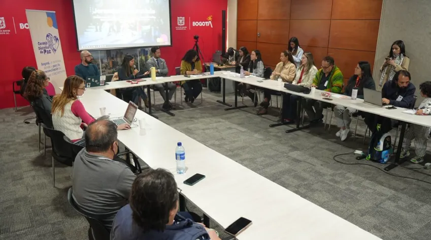 Reunión del Consejo Distrital de Paz con funcionarios y participantes alrededor de una mesa en U, en un salón institucional de la Alcaldía Mayor de Bogotá.